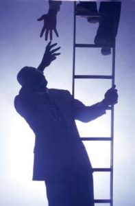 one man helping another up a ladder 